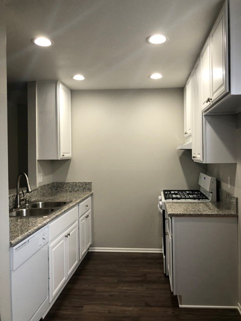 a kitchen with white cabinets and granite counter tops